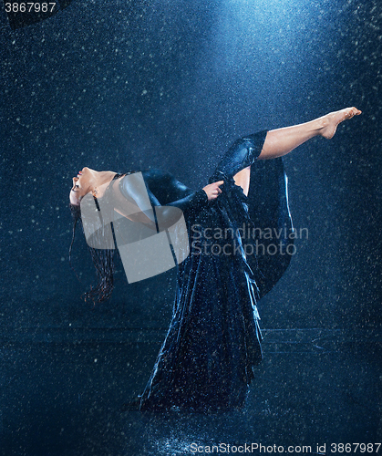 Image of The young beautiful modern dancer dancing under water drops