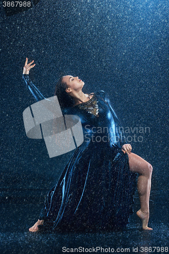 Image of The young beautiful modern dancer dancing under water drops