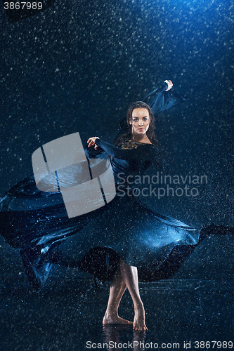 Image of The young beautiful modern dancer dancing under water drops