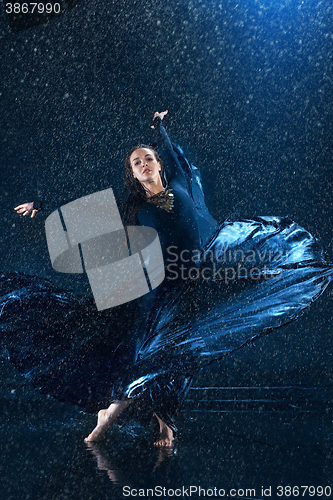 Image of The young beautiful modern dancer dancing under water drops