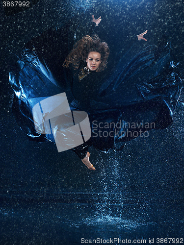 Image of The young beautiful modern dancer dancing under water drops