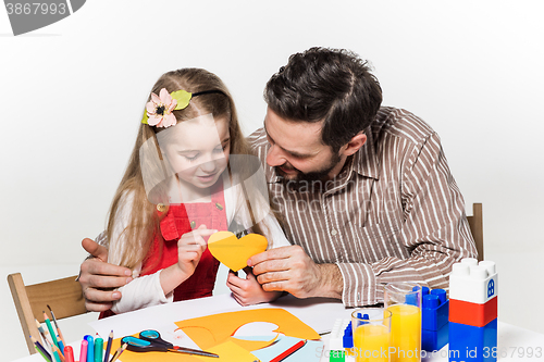 Image of The daughter and father carving out paper applications 