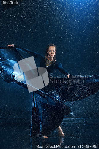 Image of The young beautiful modern dancer dancing under water drops