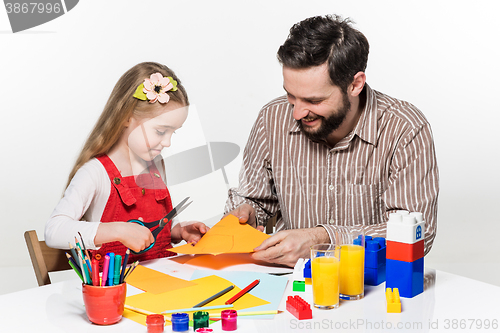 Image of The daughter and father carving out paper applications 