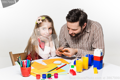 Image of The daughter and father carving out paper applications 