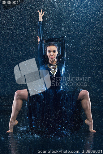 Image of The young beautiful modern dancer dancing under water drops