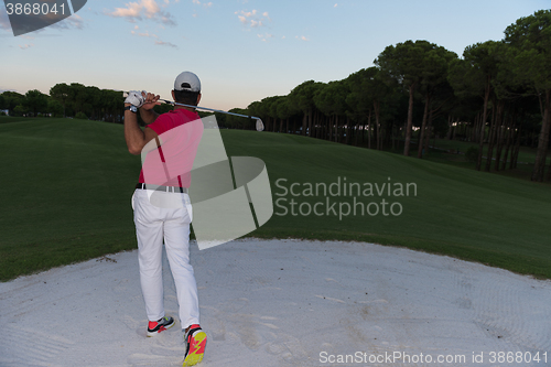 Image of golfer hitting a sand bunker shot on sunset