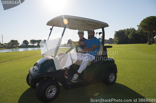 Image of golf players driving cart at course