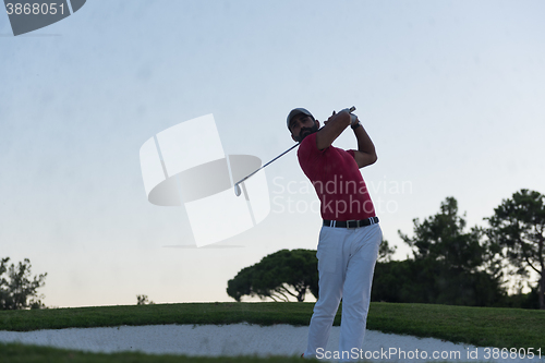 Image of golfer hitting a sand bunker shot on sunset