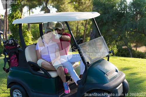 Image of couple in buggy on golf course