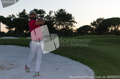 Image of golfer hitting a sand bunker shot on sunset