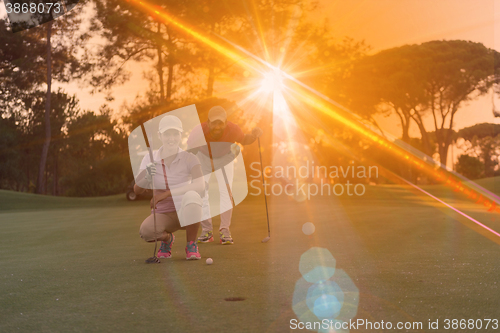 Image of couple on golf course at sunset