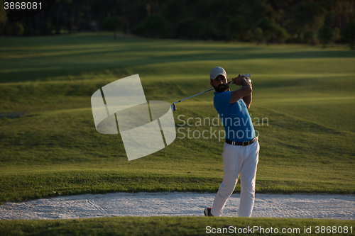 Image of golfer hitting a sand bunker shot on sunset