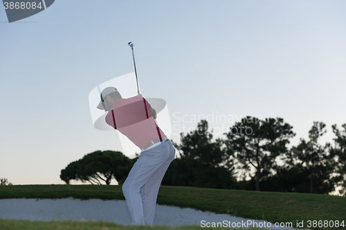 Image of golfer hitting a sand bunker shot on sunset