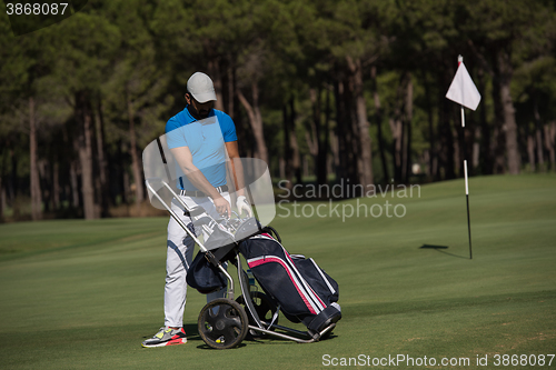 Image of golf player walking with wheel bag