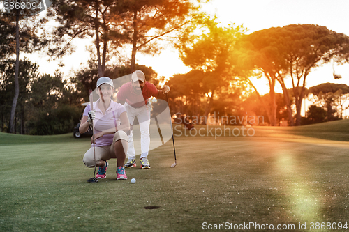 Image of couple on golf course at sunset