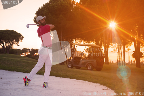 Image of golfer hitting a sand bunker shot on sunset