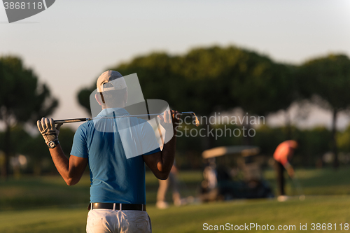 Image of golfer from back at course looking to hole in distance