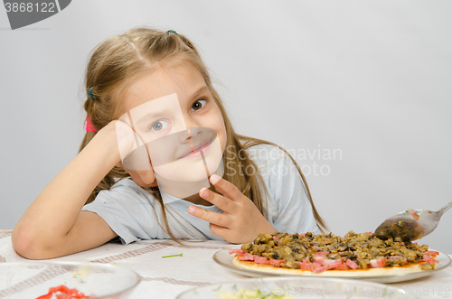 Image of Little six year old girl sitting at the table waiting for about preparing pizza