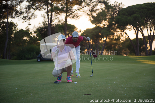 Image of couple on golf course at sunset