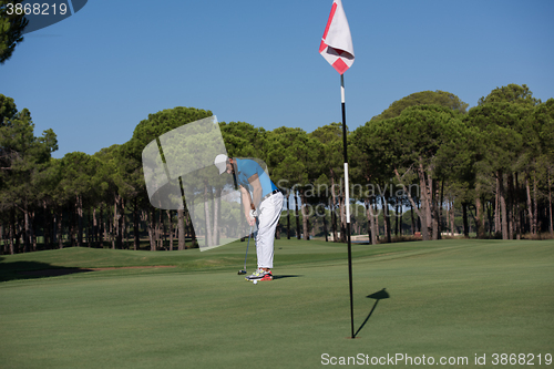 Image of golf player hitting shot at sunny day