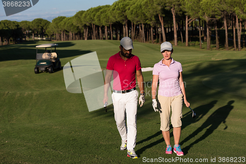 Image of couple walking on golf course