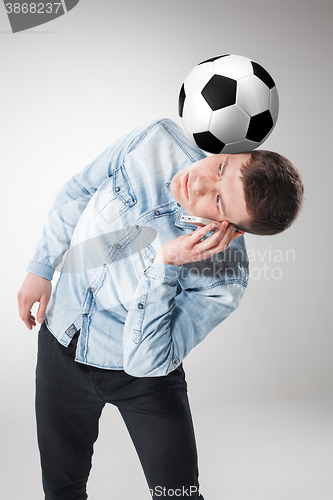 Image of The portrait of fan with ball, holding phone on white background