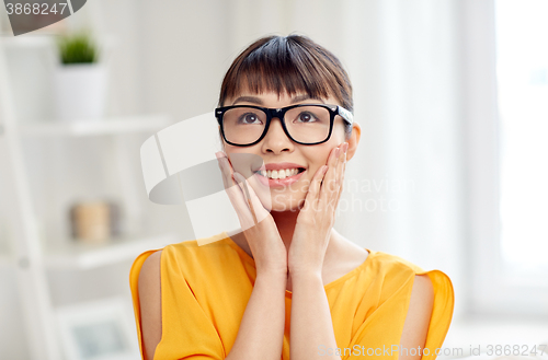 Image of happy asian young woman in glasses at home