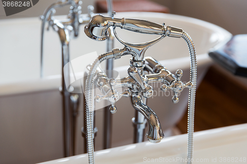 Image of close up of bath tap and shower at bathroom