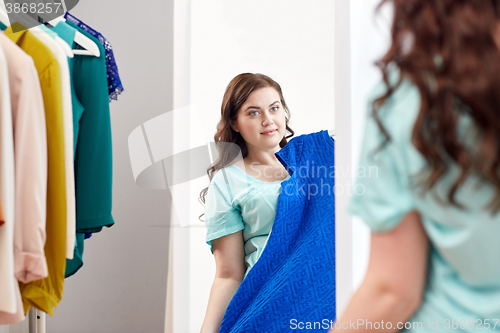 Image of happy plus size woman with dress at mirror