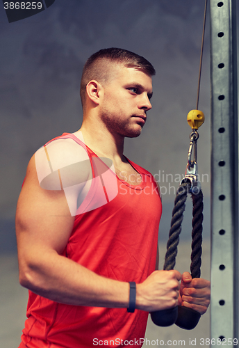 Image of man flexing muscles on cable machine gym