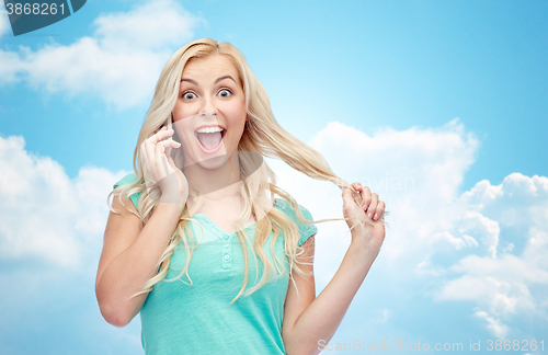 Image of smiling young woman calling on smartphone