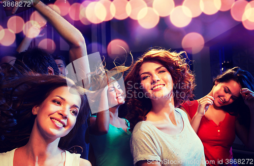 Image of smiling friends dancing in club