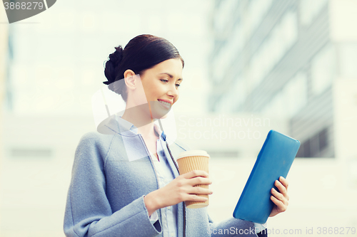 Image of smiling business woman with tablet pc in city