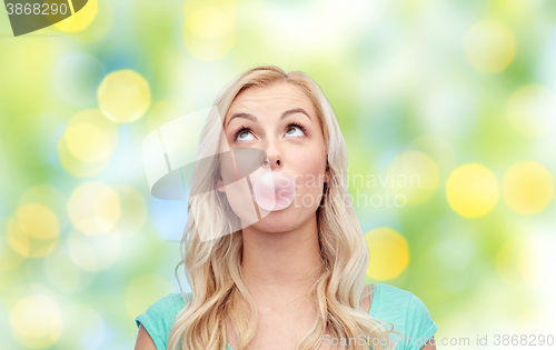 Image of happy young woman or teenage girl chewing gum