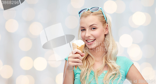 Image of happy young woman in sunglasses eating ice cream