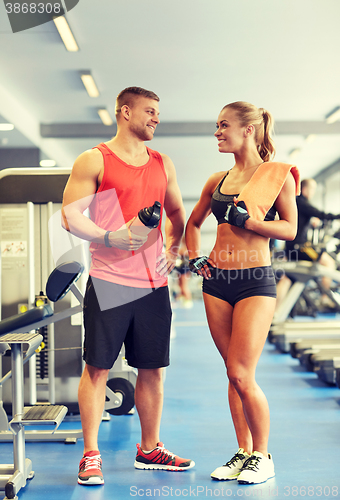 Image of smiling man and woman talking in gym