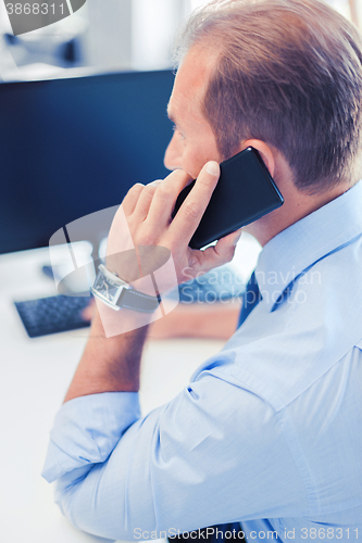 Image of businessman with smartphone in office