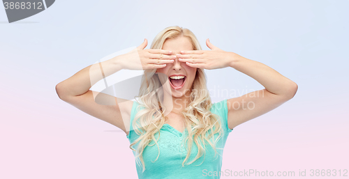 Image of smiling young woman or teen girl covering her eyes