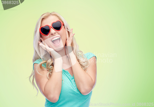 Image of happy young woman in heart shape sunglasses