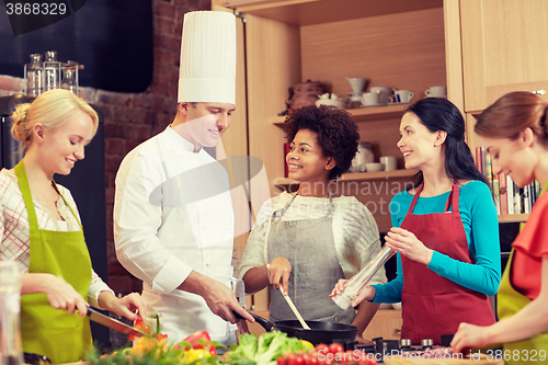 Image of happy women and chef cook cooking in kitchen