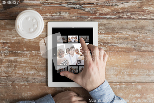 Image of close up of male hands with photo on tablet pc