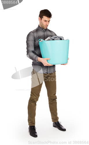 Image of Full length portrait of a young man holding a laundry basket