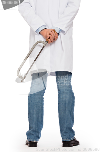 Image of Crazy doctor is holding a big saw in his hands