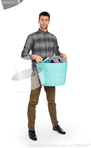 Image of Full length portrait of a young man holding a laundry basket