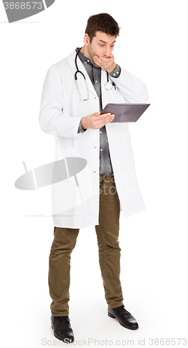 Image of Male Caucasian doctor holding a digital tablet, looking shocked