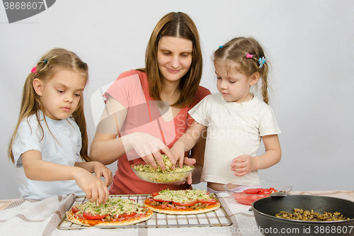 Image of Mom with two young assistants make pizza