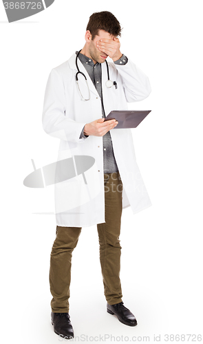 Image of Male Caucasian doctor holding a digital tablet, looking shocked