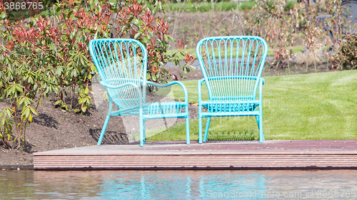 Image of Two blue chairs at the waterfront