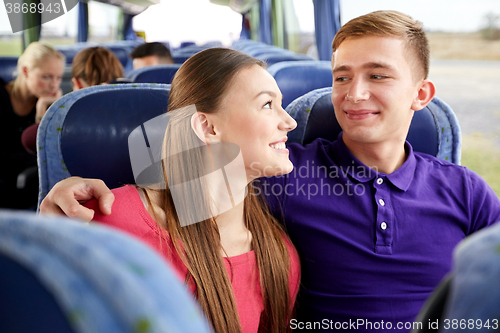 Image of happy teenage couple or passengers in travel bus